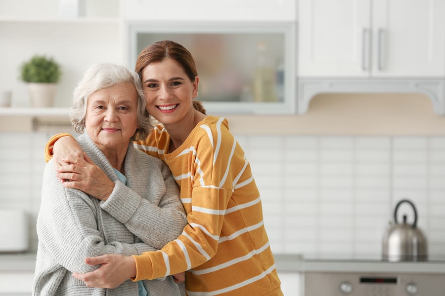 Female caregiver hugging elder, lack of stress
