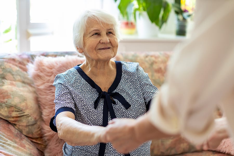 elderly woman receiving in-home care from aide