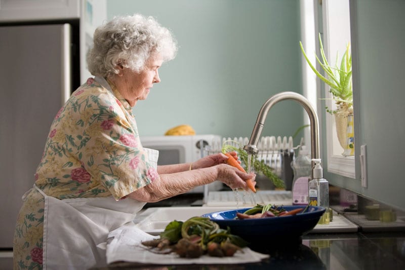 elderly woman cooking healthy for heart health
