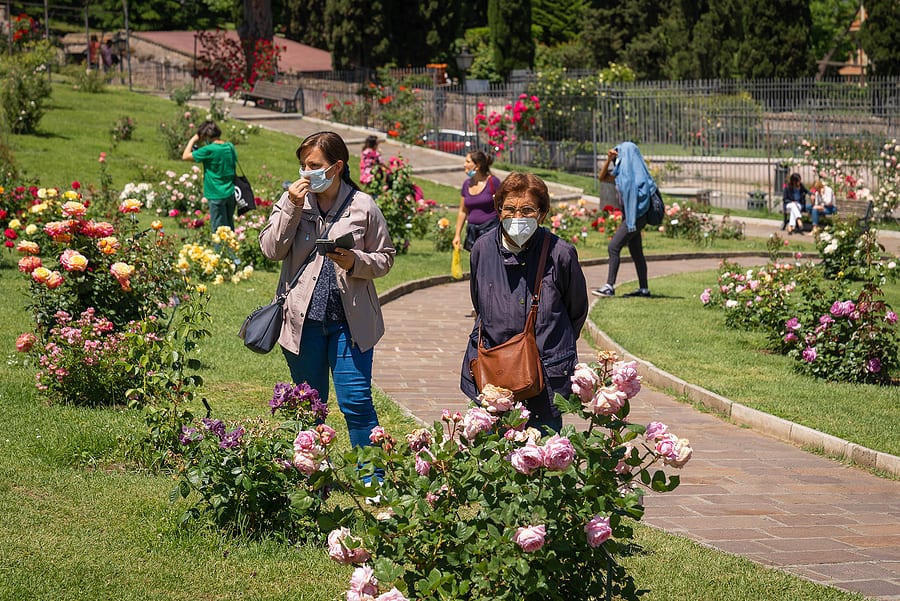 travel tips - elderly woman and her aide with masks on in garden