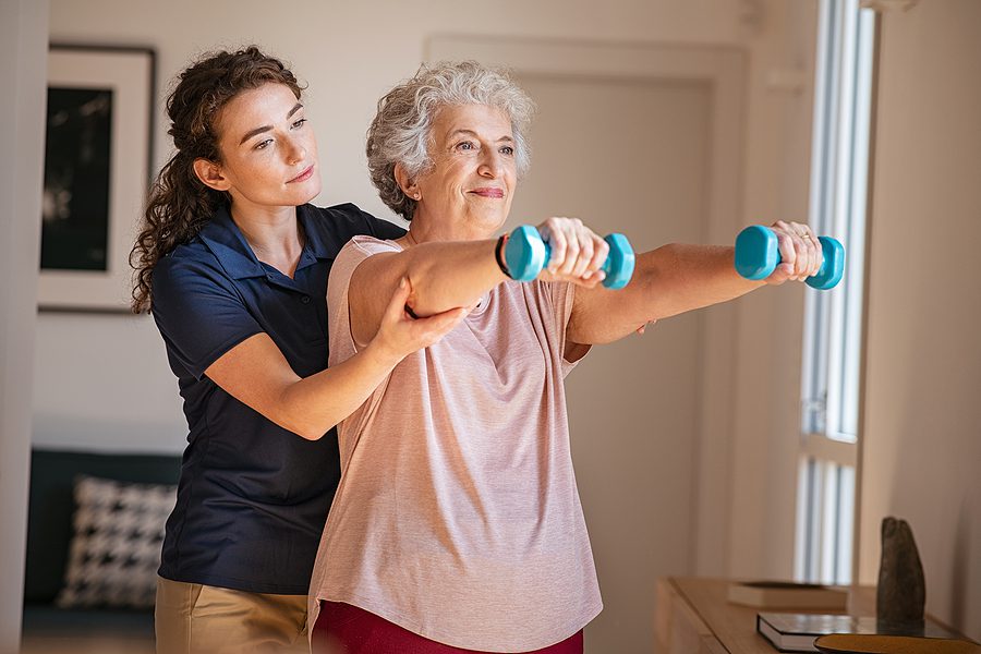 elderly woman working out with her home health aide. Building strong muscles in elderly age concept