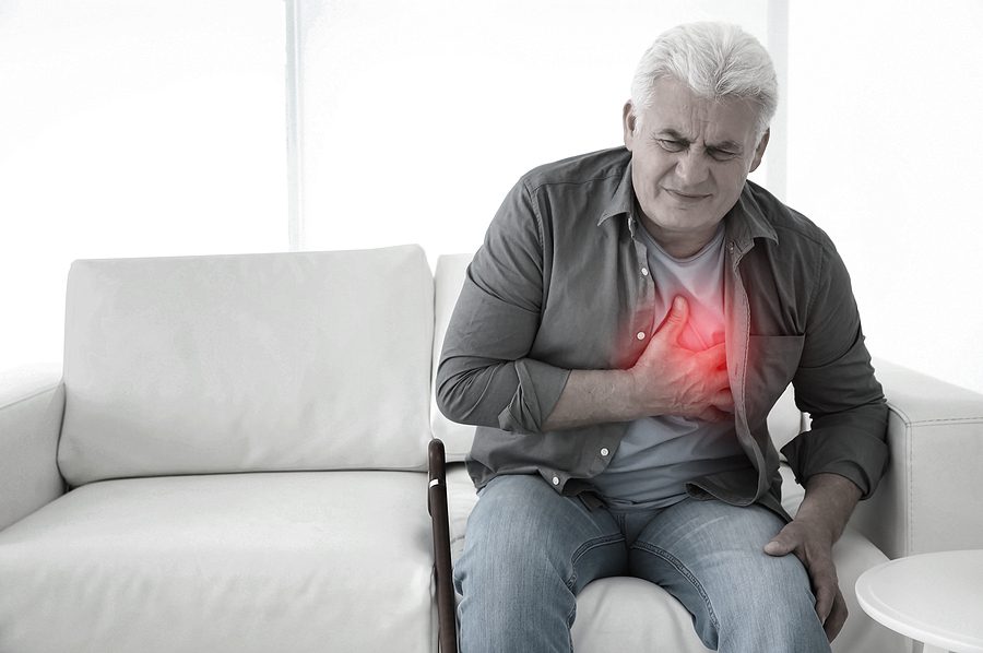 Senior man on sofa with heart failure. Red color radiating from chest - heart failure concept