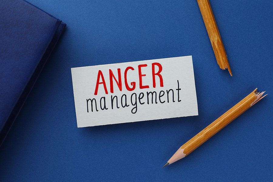 Anger management concept - blue field with a broken pencil and a card that says "anger management"