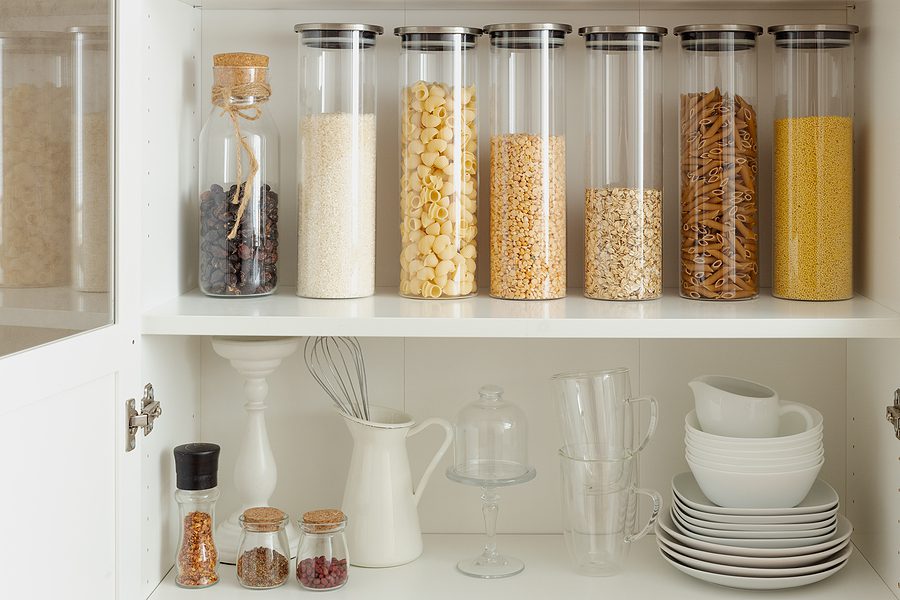 organized pantry in kitchen - glass jars holding staple dry ingredients
