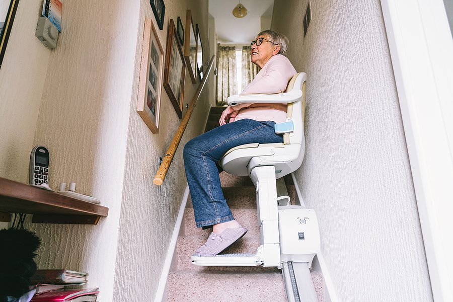 senior woman on stair lift - fall prevention concept