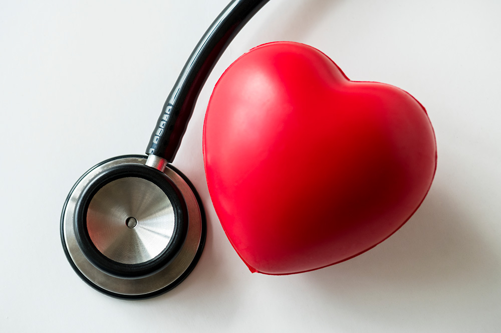 A closeup of a plastic heart and a stethoscope - heart health concept