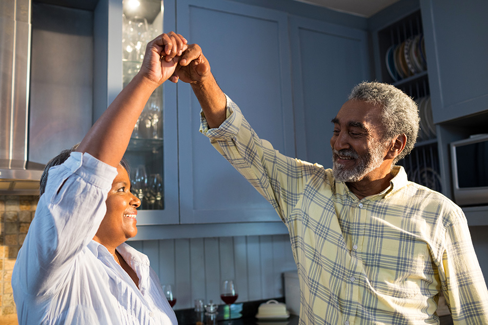 older couple dancing to music in the kitchen