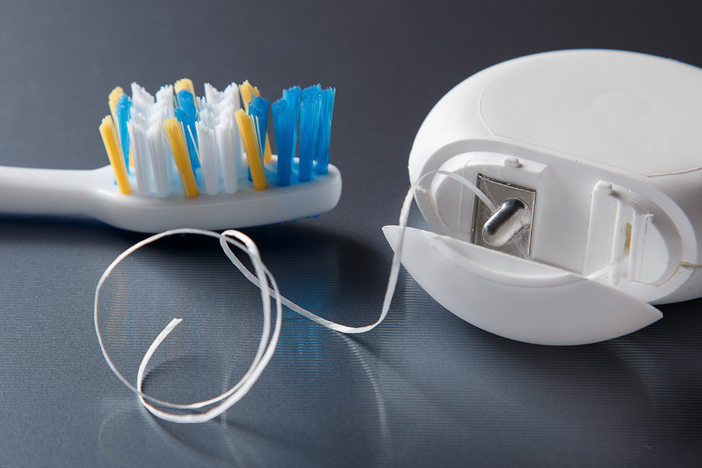 toothbrush and dental floss - dental care for older adults concept