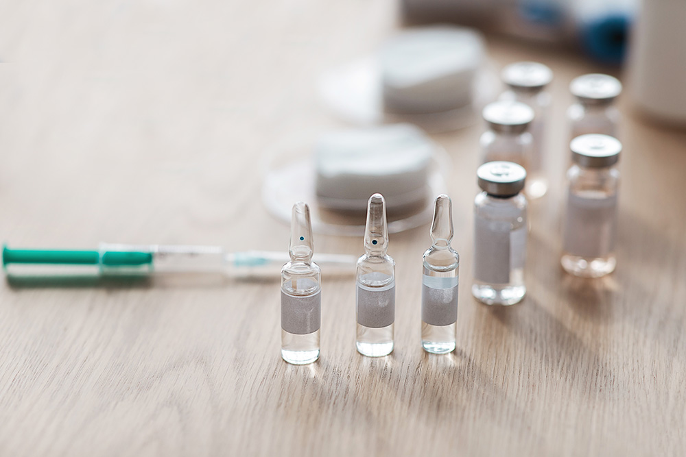 Ampoules, vaccination bottles and a syringe for vaccines - vaccines for older adults concept