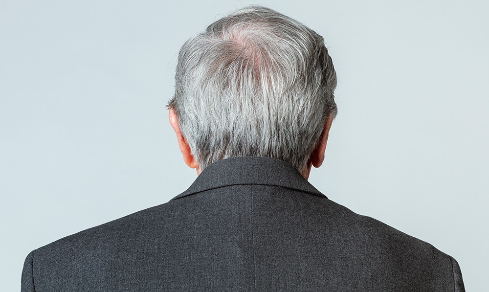 older man with thinning hair along the crown of his head, seen from behind - hair thinning and hair loss concept