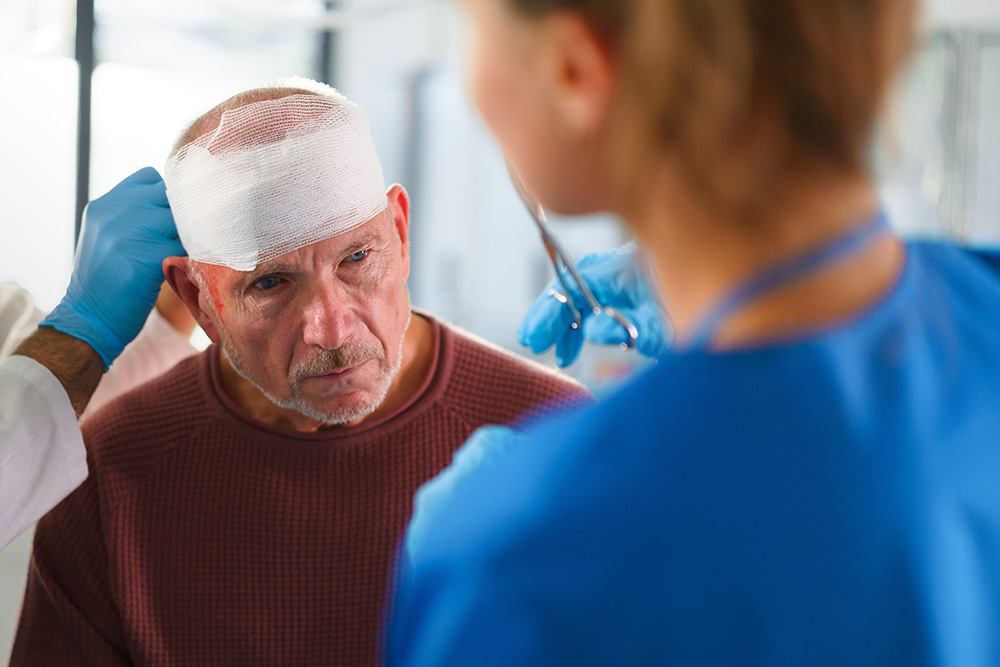 older man being treated for tbi in a hospital - traumatic brain injury in older adults concept