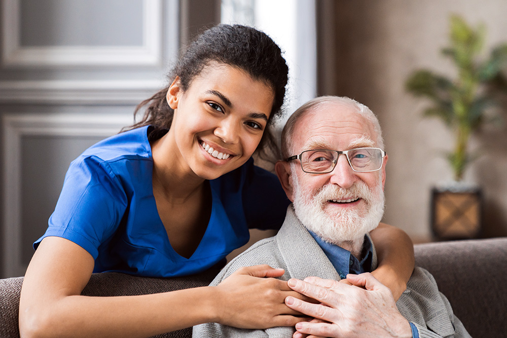 caregiver hugs older man - caregiver assisted living concept