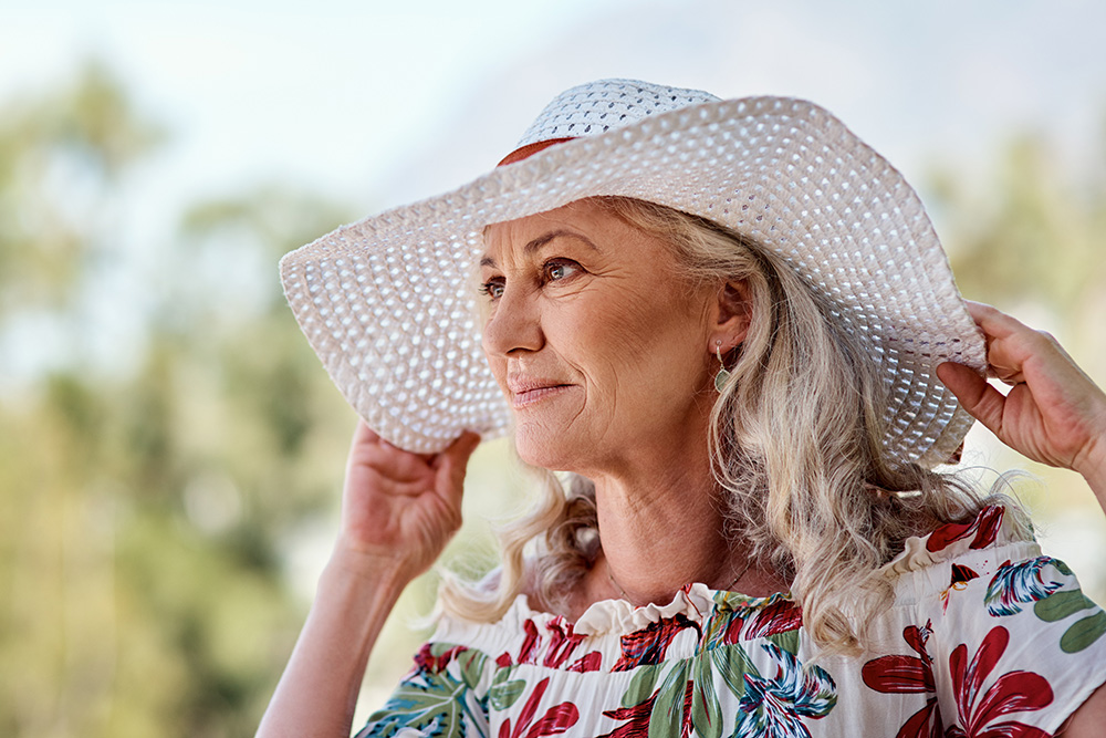older woman with sunhat staying cool in the summer