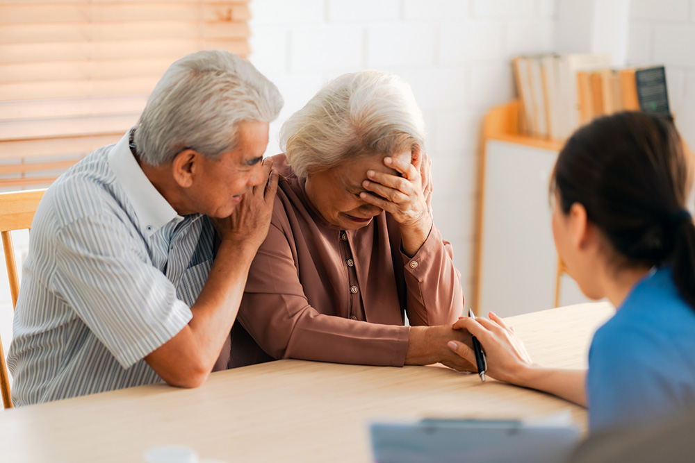 older couple discussing abuse with a health care professional